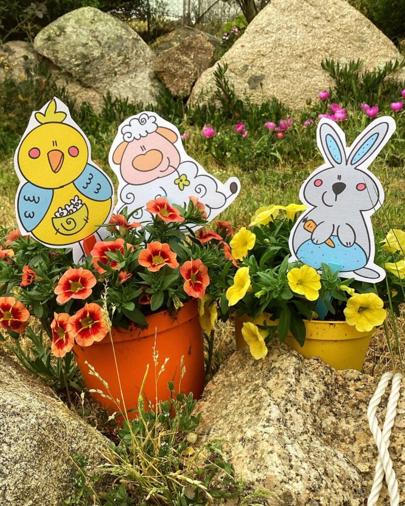 Vasetti di fiori decorati con sagome illustrate di personaggi primaverili, usati come attività creativa per bambini e bambine
